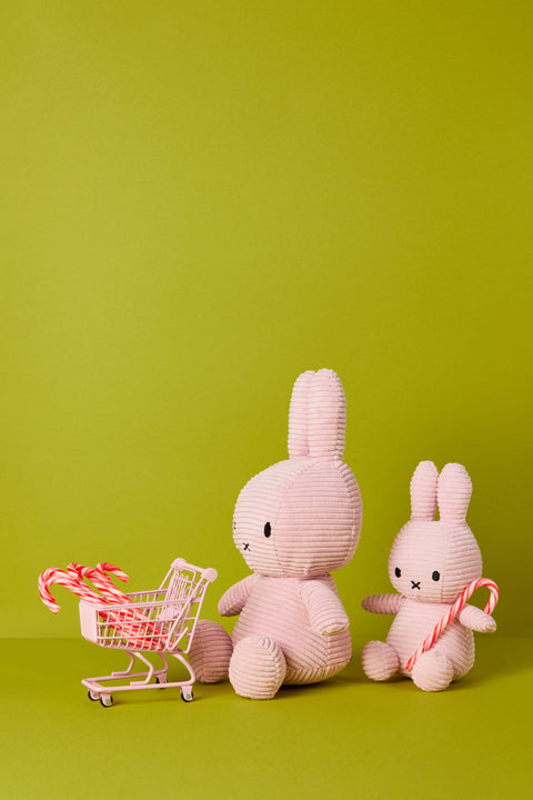 Two Miffy's in pink corduroy with candy canes on a green background